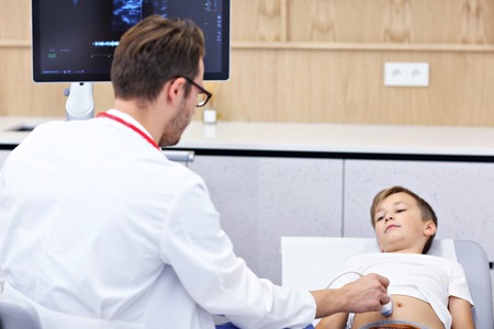 Doctor testing young boy with usg
