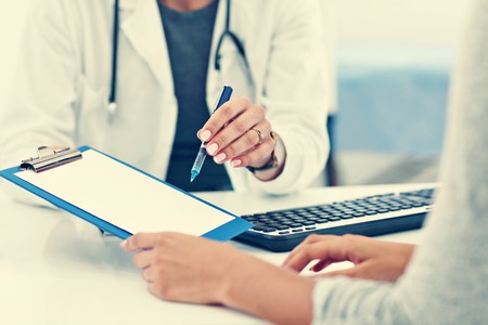 Adult woman having a visit at female doctors officeの写真素材