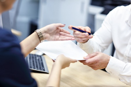 Midsection of hands holding documents and penの写真素材