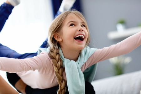 Beautiful mom and her daughter having fun at home