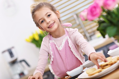 Cute little girl preparing cookies in the kitchenの写真素材