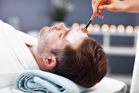 Handsome man having facial in spa salonの写真素材