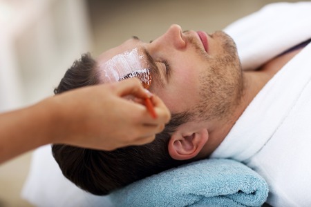 Handsome man having facial in spa salonの写真素材