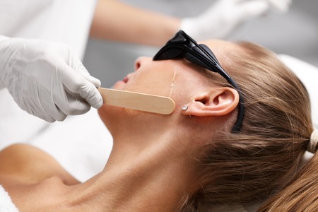 Beautician Giving Epilation Laser Treatment To Woman On Face