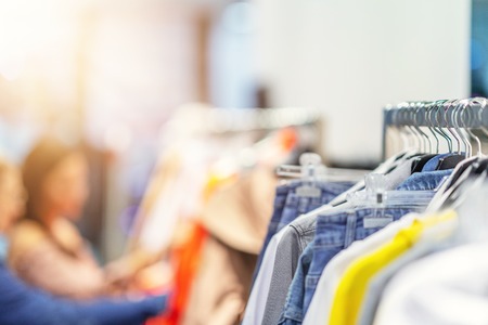 Girl friends shopping for clothes in storeの写真素材