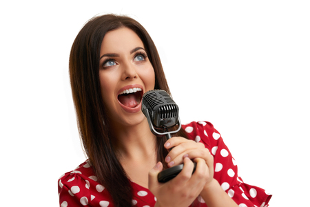 Caucasian brunette woman having fun and singing isolated over white backgroundの写真素材