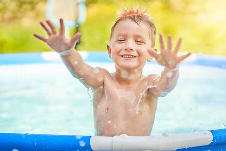 Cute boy swimming and playing in a backyard poolの写真素材