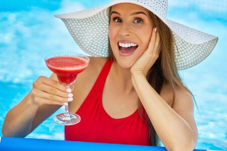 Close up view of attractive woman relaxing on swimming pool in the backyardの写真素材