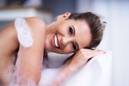 Close-up portrait of a young woman relaxing in the bathtubeの写真素材