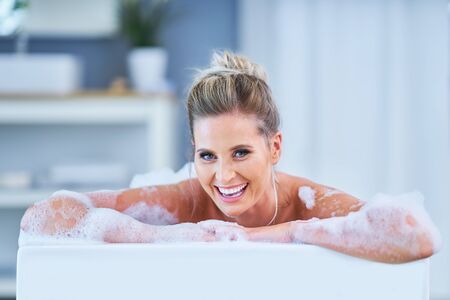 Portrait of a young woman relaxing in the bathtube