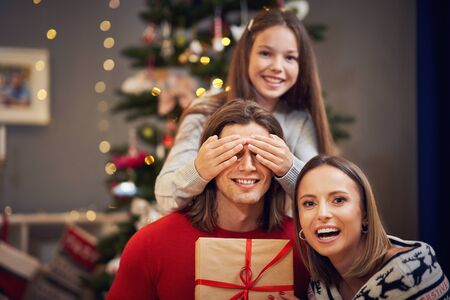 Beautiful family with presents over Christmas treeの写真素材
