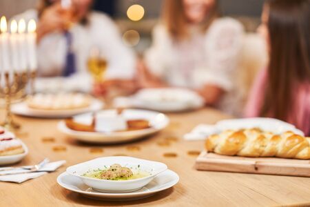 Hanukkah dinner. Family gathered around the table with traditional dishesの写真素材