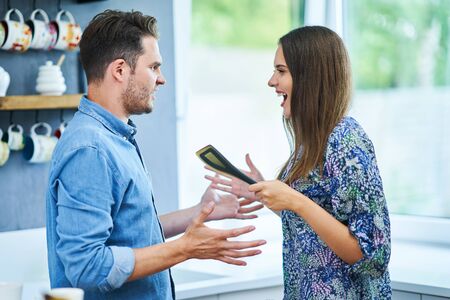Couple in home kitchen using electronic tablet