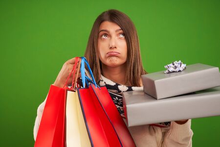 Adult happy woman shopping for Christmas presents over green background