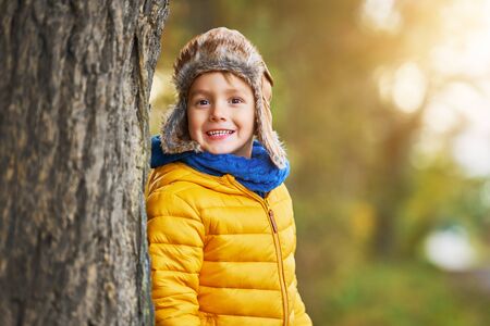 Happy child boy playing outside in autumn