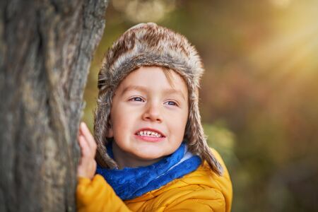 Happy child boy playing outside in autumn