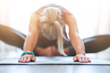 Adult woman practising yoga at homeの写真素材