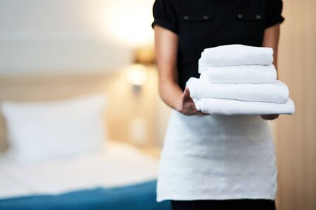 Maid with fresh towels in hotel roomの写真素材