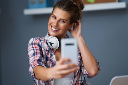 Female student learning at home and taking selfie