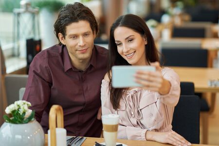 Young Couple taking selfie In Cafe