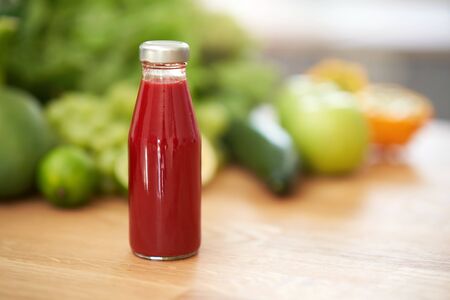 Bottle of smoothie oresh green fruit and vegetables on wooden counterの写真素材