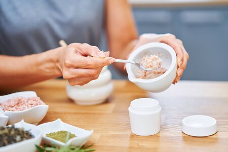 Beautiful healthy woman preparing natural cosmetics at homeの写真素材