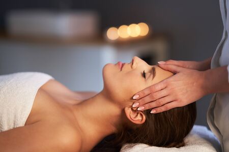 Relaxed woman receiving head massageの写真素材