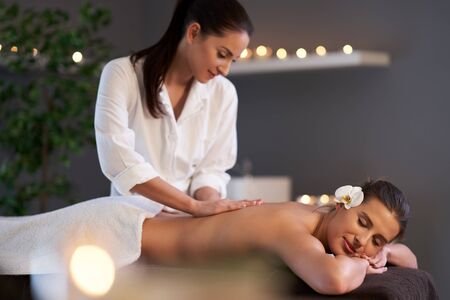 Relaxed woman receiving back massageの写真素材