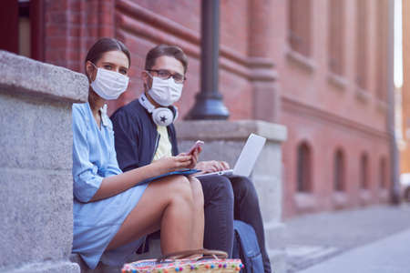 Couple of students in the campus wearing masks due to coronavirus pandemicの写真素材