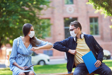 Couple of students in the campus wearing masks due to coronavirus pandemicの写真素材