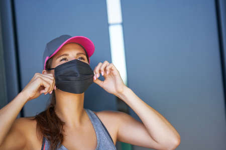 Female runner using protective mask during coronavirus pandemicの写真素材