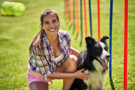 Border collie dog and a woman on an agility field