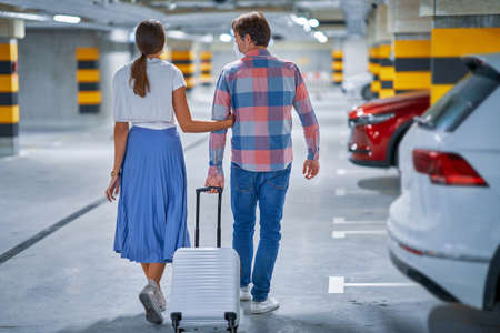 Couple of tourists in underground airport parking lotの写真素材