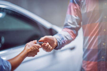 Car dealer giving keys to a customerの写真素材