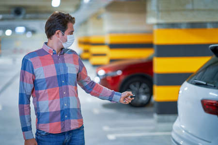 Student in mask leaving car in underground parking lotの写真素材