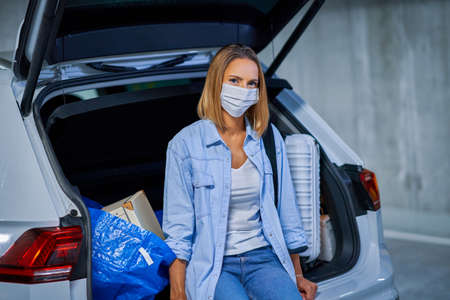 Adult woman tourist wearing mask in underground airport parking lot