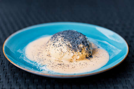 Steamed sweet dumpling bun topped with poppy seeds and vanilla sauce.の写真素材