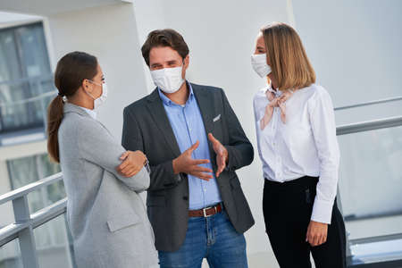 Team of businesspeople working in protective masksの写真素材