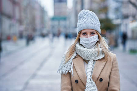 Woman wearing face mask because of Air pollution or virus epidemic in the cityの写真素材