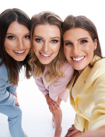 Three women in pastel suits posing over white backgroundの写真素材