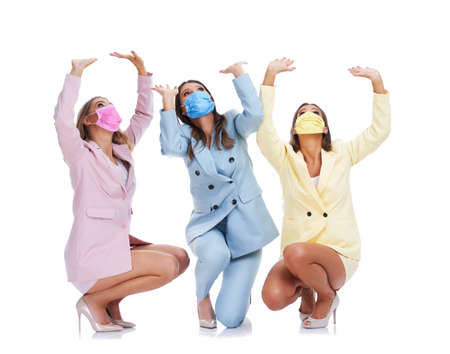 Three women in pastel suits posing over white backgroundの写真素材
