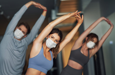 Group of people wearing masks working out in a gymの写真素材