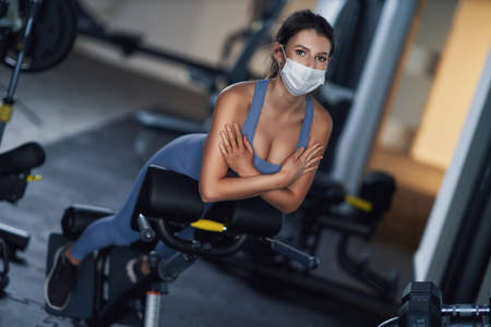 Adult woman working out in a gym in maskの写真素材