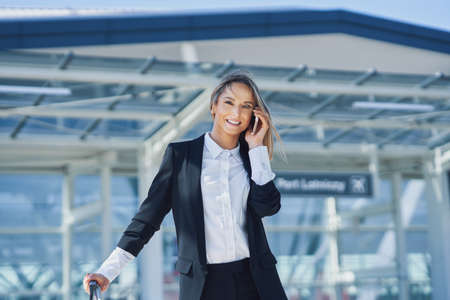 Adult female passenger using smartphone at the airportの写真素材