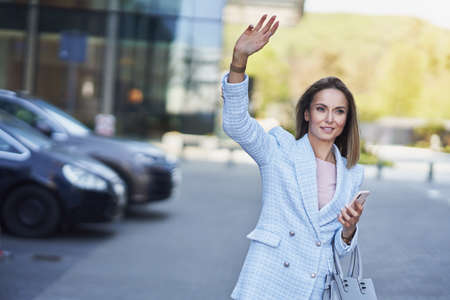 Business woman catching a taxi in the city