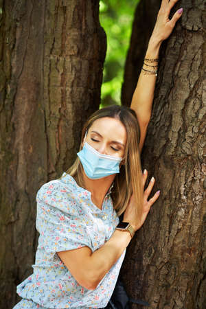 Young woman in the mask walking outdoorの写真素材