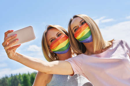 Woman wearing lgbt flag outdoor taking selfie.の写真素材