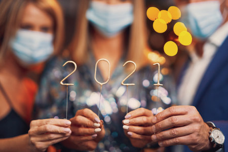 Beautiful young friends in masks having fun at New Years Eve Party 2021 2022の写真素材