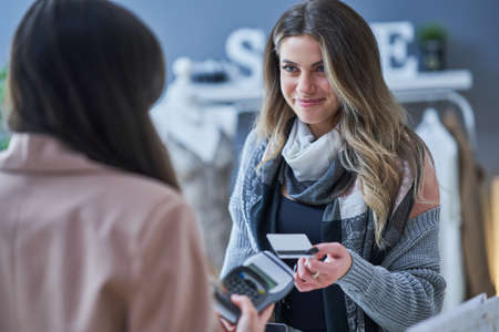 Woman seller and buyer in clothes storeの写真素材
