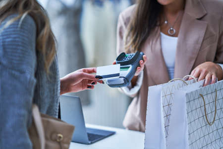 Woman seller and buyer in clothes store